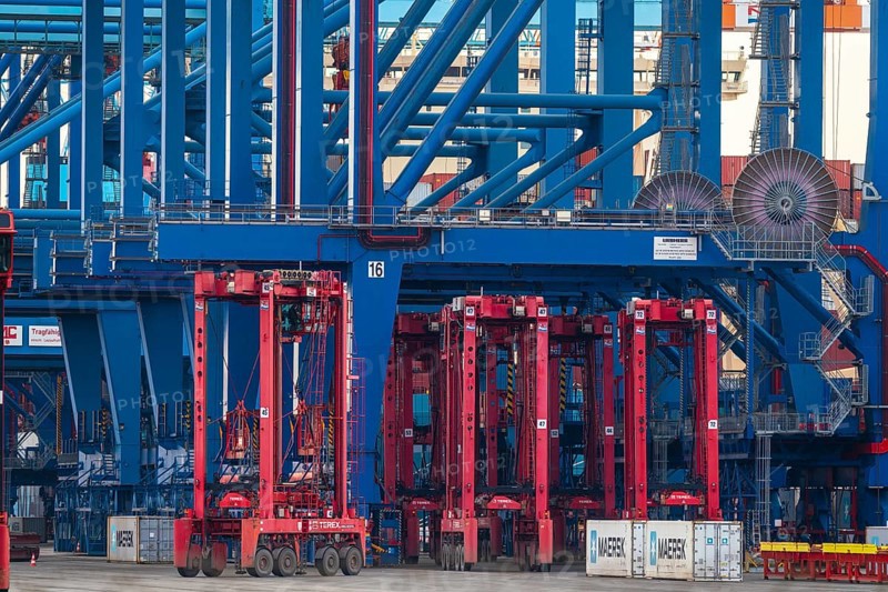 Industrial complex with large blue and red container cranes in action