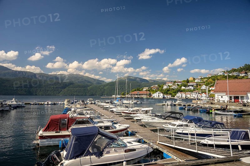 Sand, Rogaland Municipality, Norway, boats in harbor on a sunny day with mountains in the background