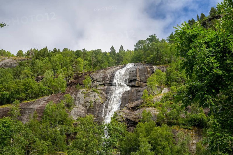 Åndalsnes, Møre og Romsdal Province, Norway, High Waterfall flows over steep rocks surrounded by lush greenery and trees