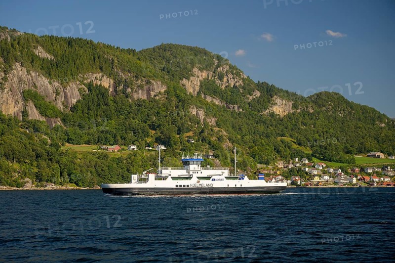 Hjelmeland, Rogaland Municipality, Norway, ferry on a fjord in front of a wooded landscape with mountains