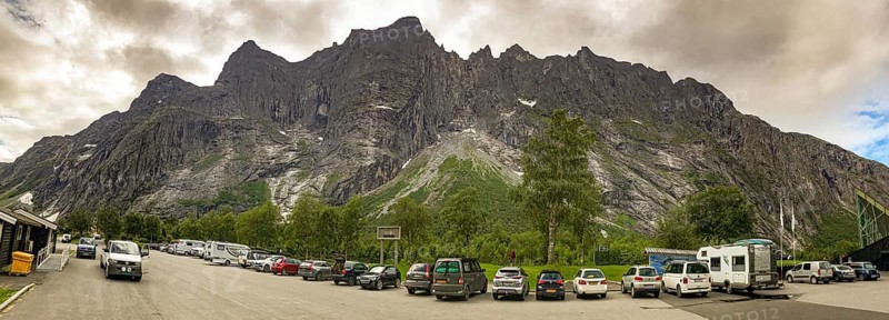 Åndalsnes, Møre og Romsdal province, Norway, mountain panorama on the Trollveggen rock face with parked cars against dramatic cloudy sky