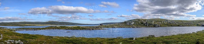 Haugastøl, Viken, Norway, vast landscape with a lake under a cloudy blue sky in Hardangervidda