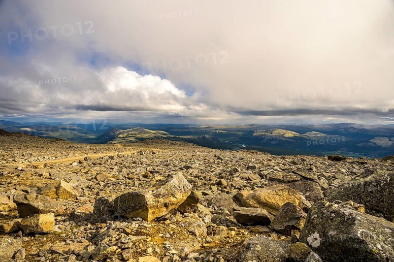 Alvdal, Innlandet, Norway, far-reaching view over a rocky landscape under a dramatic sky, road to Tronfellet with an altitude difference of 1161 m the highest navigable road in Norway