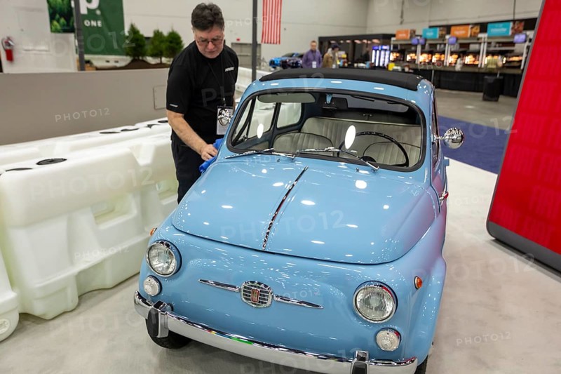 Detroit, Michigan USA - 15 January 2026 - A worker polishes a 1962 Fiat 500 at the Detroit Auto Show