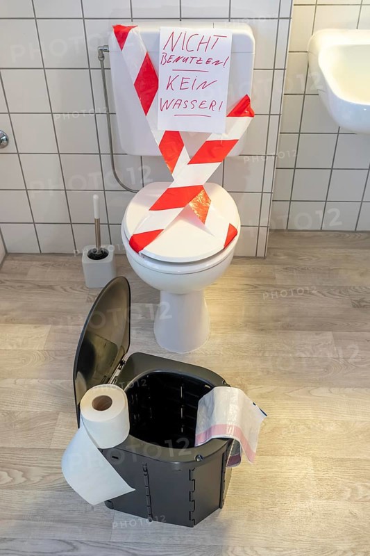 Symbolic picture blackout, extensive, prolonged power failure, in private environments, without electricity, the water supply also fails, toilet flush no longer works, emergency toilet, mobile toilet, camping toilet as an emergency replacement, disposal in bags