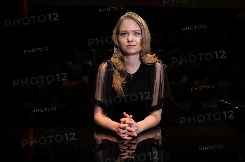 Young woman, pianist, in evening dress, with folded hands supported on Steinway & Sons grand piano, Stuttgart, Baden-Württemberg, Germany