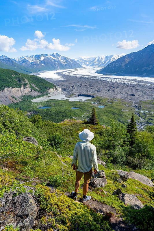 Young man enjoying the view, view of impressive mountain landscape with Matanuska glacier and glaciated mountain peaks, Lion's Head, Chugach Mountains, Alaska, USA