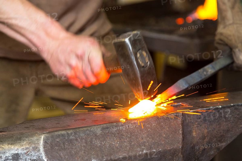 Sparks spray, a blacksmith forging, working at the Ehnert forge in Dresden-Bühlau, Saxony, Germany