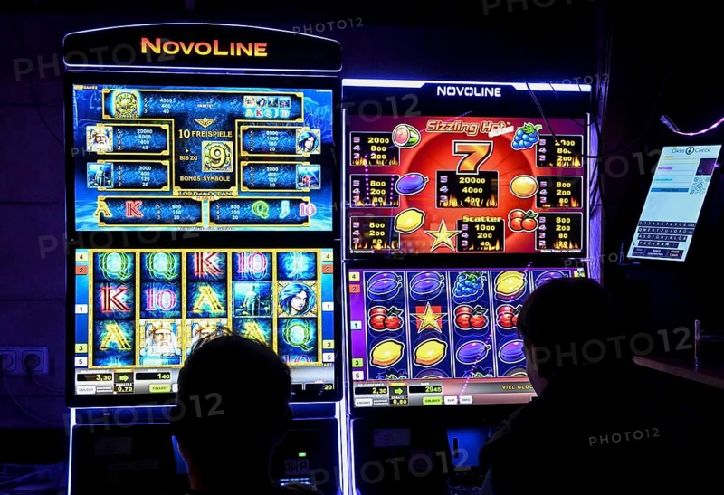 Guests at a pub in front of slot machines, Munich, Bavaria, Germany
