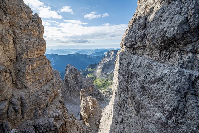 View from the Bocca degli Armi gap, mountaineers on a rock band on the Via Ferrata Bocciere Centrale via ferrata, Brenta Mountains, Brenta-Adamello Natural Park, Trentino, Italy