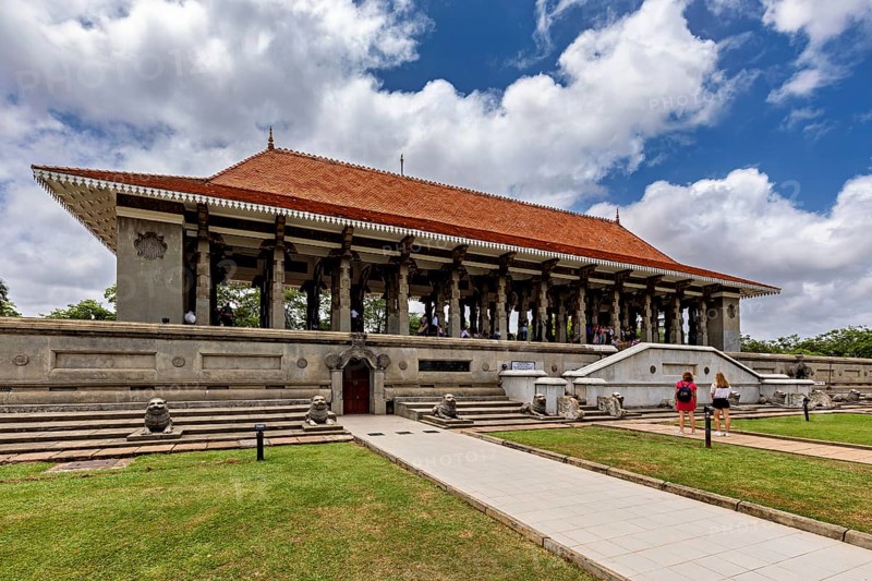 A long building with pillars and a distinctive roof surrounded by lawns on a cloudy day, Colombo Sri Lanka's City Hall