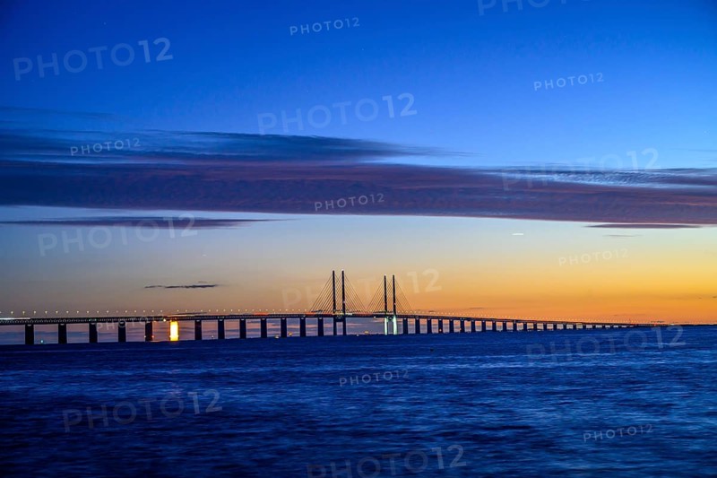 Modern Øresund bridge across the sea at sunset with colorful sky illuminated by a colorful sunset, Malmö, Skane län, Sweden
