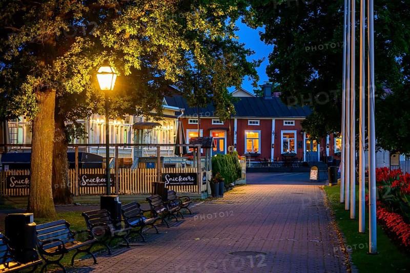 Illuminated alley in the old town of Naantali with benches and trees at dusk, cozy atmosphere, Naanatali, Varsinais-Suomi, Finland