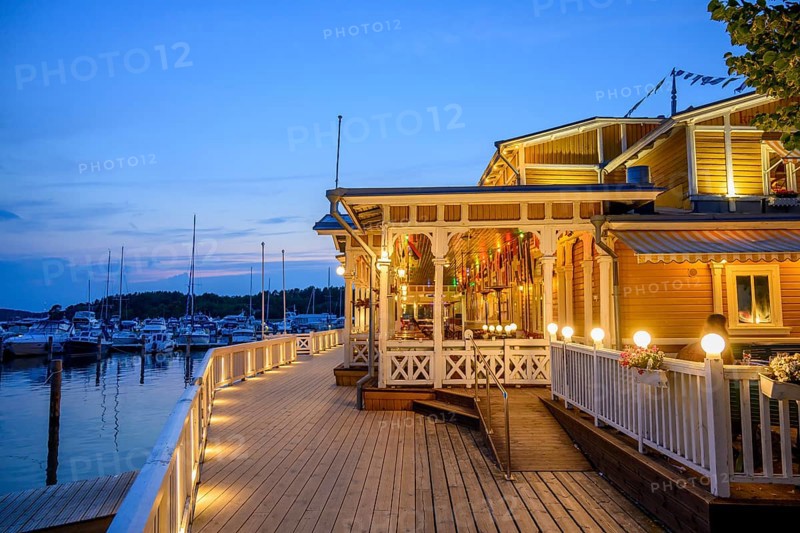 Historic harbour bridge with a warmly lit Merisali restaurant at the marina marina, Naanatali, Varsinais-Suomi, Finland