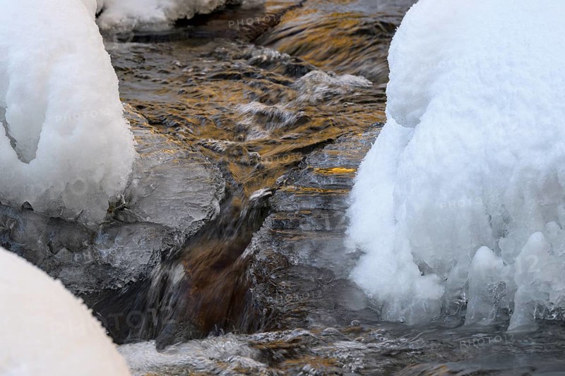 Ilsenburg, Saxony-Anhalt, Germany, close-up of water snaking through icy and snow-covered banks on the Ilse River in the Harz National Park on the Heinrich-Heine Weg Ilsetal hiking trail