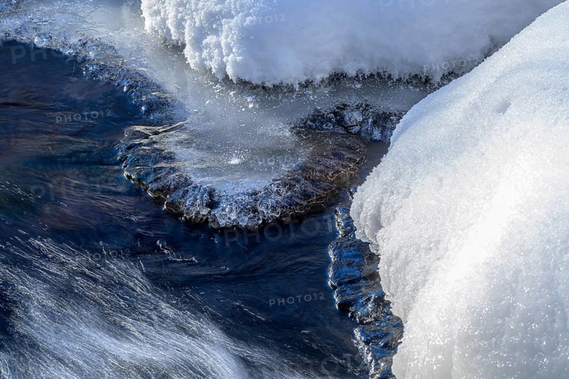 Ilsenburg, Saxony-Anhalt, Germany, detailed view of ice and snow on a flowing body of water on the Ilse river in the Harz National Park on the Heinrich-Heine trail Ilsetal