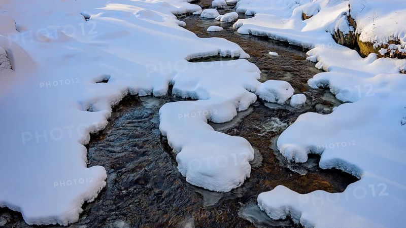Ilsenburg, Saxony-Anhalt, Germany, snowy Ilse river in the Harz National Park on the Heinrich-Heine trail Ilsetal hiking trail, illuminated by light and shadow in winter