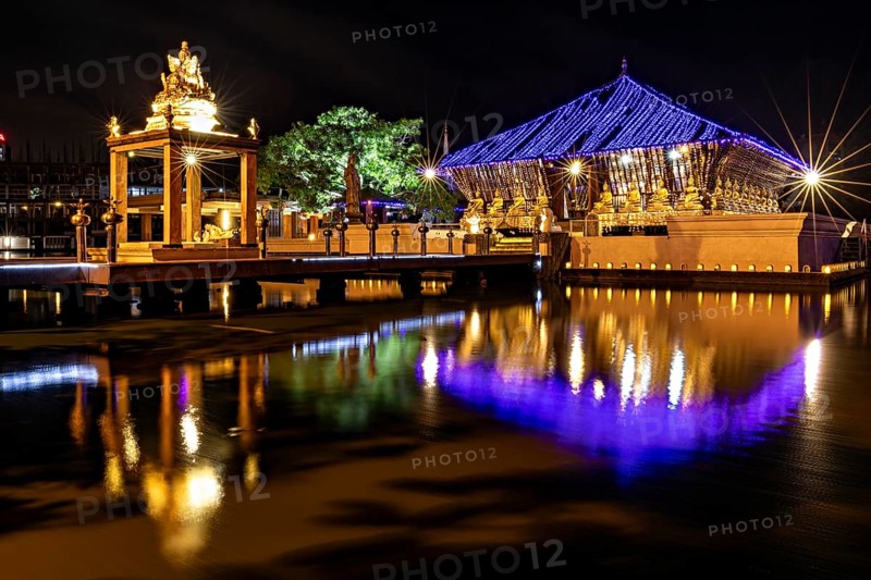 Night scene of an illuminated temple whose lights are reflected in the water, The Seema Malaka Temple with the Buddha statues in Colombo Sri Lanka