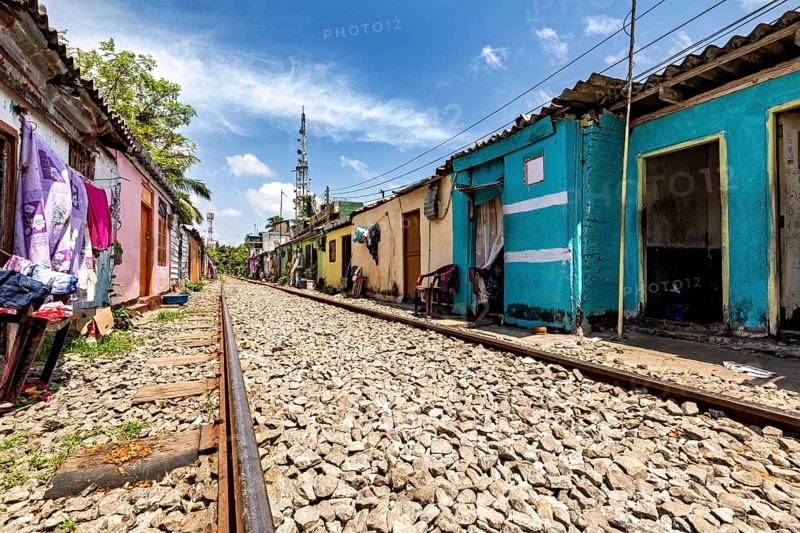 Empty railroad line lined with colorful houses lined up under cloudy sky, railway line in the historic Slave Island district of Colombo Sri Lanka