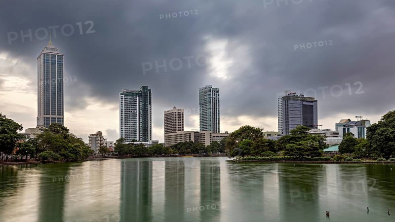 Cityscape with skyscrapers and a lake under a cloudy sky, the skyline of Colombo Sri Lanka at night