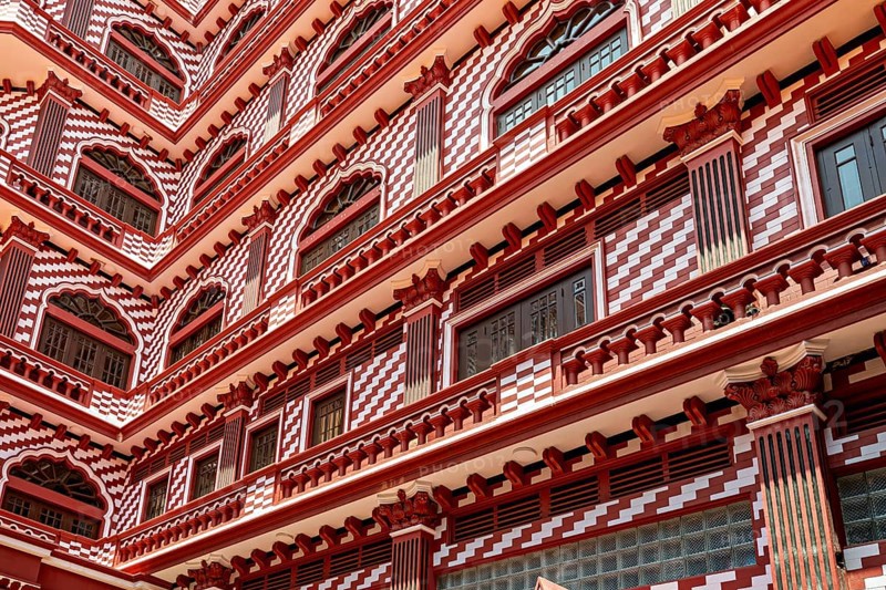 Detailed view of a red building façade with symmetrical window and pattern design, the old town with the red mosque in Colombo Sri Lanka
