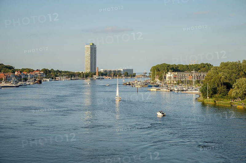 The river Trave crosses the city with a high-rise building and boats just in front of it flows into the Baltic Sea, Lübeck-Travemünde, Schleswig-Holstein, Germany