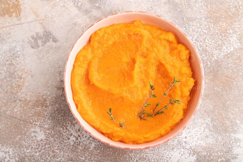 Sweet potato porridge in ceramic bowl on brown concrete background. Diet, healthy eating concept. top view, flat lay, close up