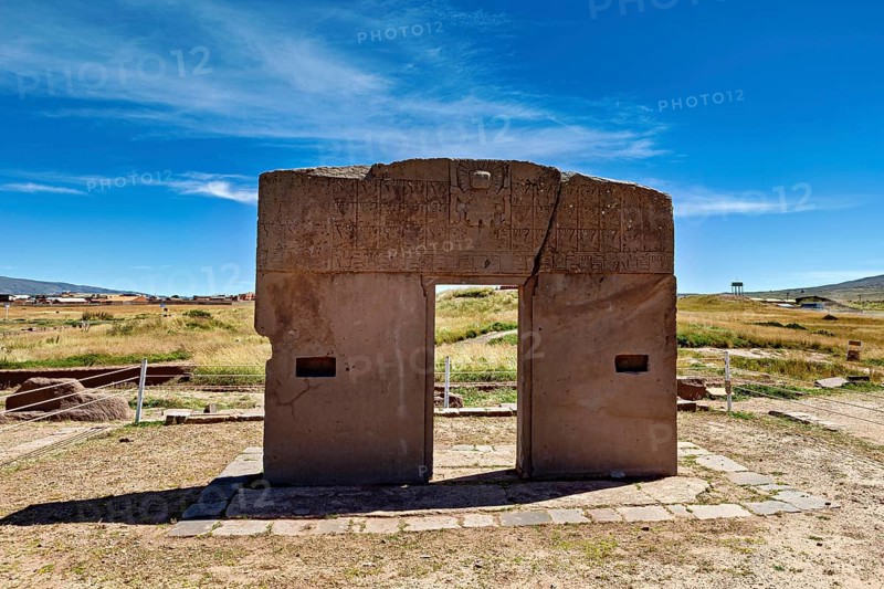 Monumental stone gate on a wide area with blue sky in the background, The archaeological site with the ruins of Tiwanaku in Bolivia