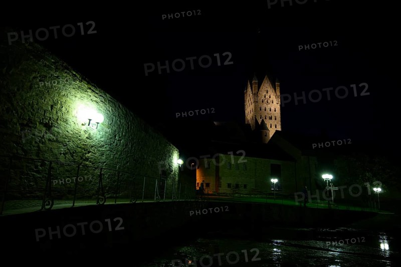 A Gothic church illuminated at night with illuminated tower and dark sky in the foreground the Kaiserpfalz, Paderborn, North Rhine-Westphalia, Germany