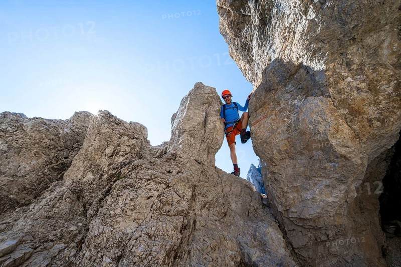 Mountaineers between rocks on the Via Ferrata Bocciere Centrale Via Ferrata, Sun Star, Brenta Mountains, Brenta-Adamello Natural Park, Trentino, Italy