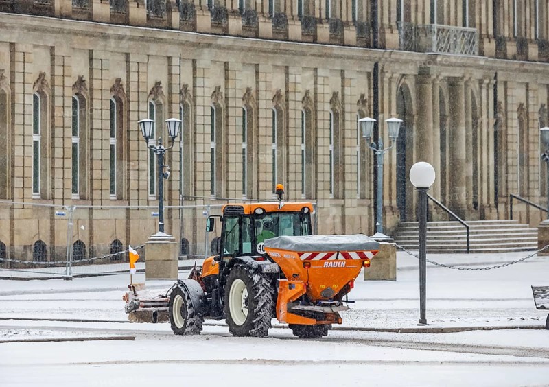 Winter in Stuttgart. There is a closed blanket of snow in the city center. Winter cleaning service on Schlossplatz in front of the New Palace. Roads and paths are freed from snow and sprinkled. Stuttgart, Baden-Württemberg, Germany