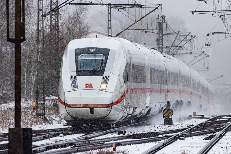 ICE traveling through a winter landscape in snowfall. A train on the line in the Deutsche Bahn Amstetten rail network, Baden-Württemberg, Germany