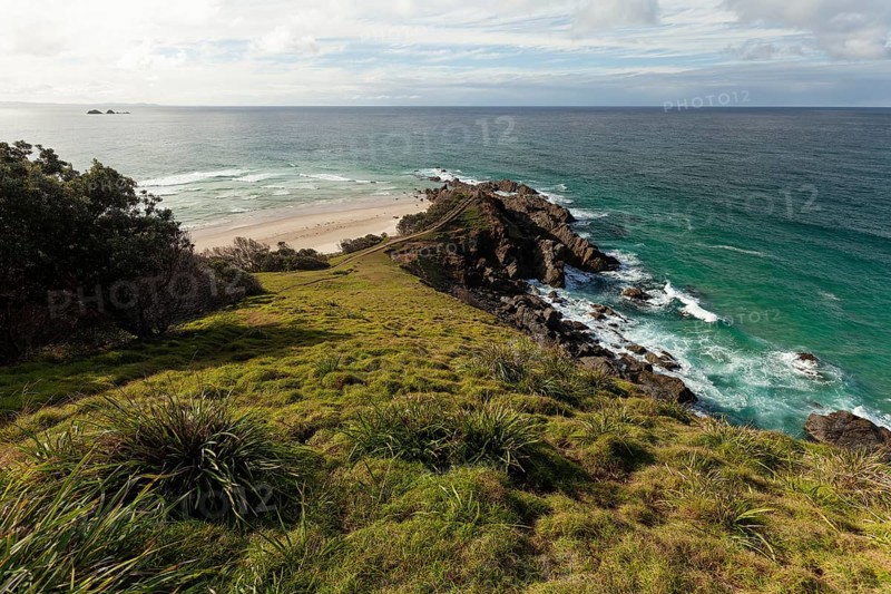 Sunlit daytime view with lookout platform below and glowing cliffs at Cape Byron, New South Wales, Australia