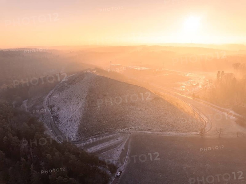 Landscaped hills in the pink-yellow light of sunrise, old deposit, construction site for PV open space plant, Lindenrain, Calw, Germany