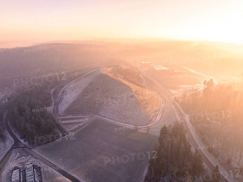 Snowy hill in soft morning light, surrounded by fog, old deposit, construction site for PV open space system, Lindenrain, Calw, Germany