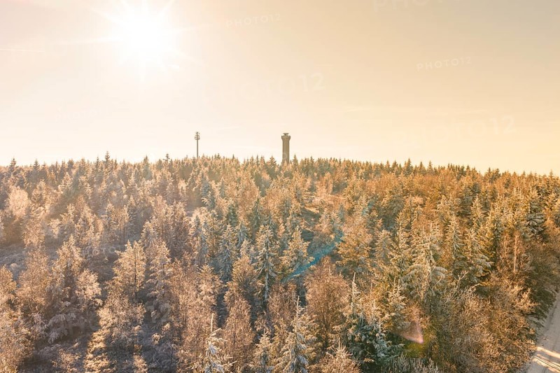 A bright winter sun over a snowy landscape with tower, Holohturm, Gernsbach, Rastatt district, Germany