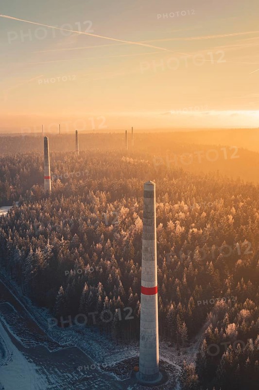 Wind turbine towers over a forest criss-crossed with snow trails, in warm sunlight, create a mystical landscape up to the horizon, Windkraft Bau, Besenfeld, Seewald, Freudenstadt district, Germany