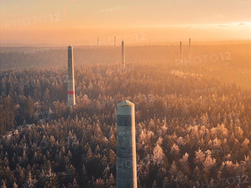 Wind turbine towers rise above a sea of forest, soft shades of fog characterize the twilight hour, Windkraft Bau, Besenfeld, Seewald, Freudenstadt district, Germany