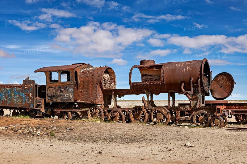 Rusty locomotive shows clear damage in an abandoned desert landscape, old rusty locomotives at the train cemetery near Uyuni in the Altiplano in Bolivia
