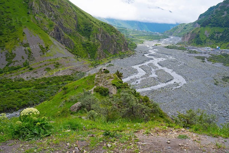 View of a green valley with a riverbed and surrounding mountains under cloudy sky, Tergi River, Terek, Tergital, Kazbegi, Stepansminda, Georgian Military Road, Mtskheta-Mtianeti Province, High Caucasus, Georgia