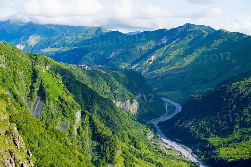 Green alpine landscape with a meandering river and majestic mountains in the background, landscape near Gudauri, view of the White Aragvi River, Mtskheta-Mtianeti region, Georgian Military Route, High Caucasus, Georgia