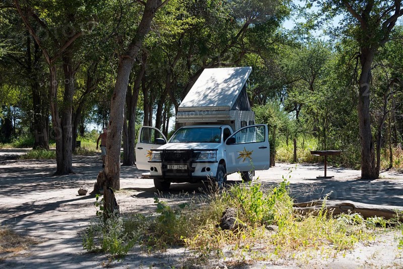 Motorhome on a shady woodland surrounded by trees and sunshine, 4WD motorhome, camper, bushcamper, Botswana