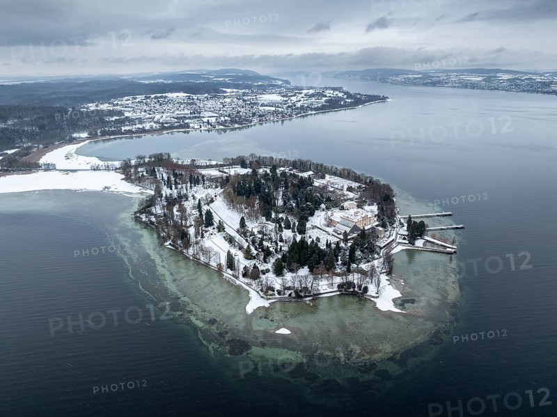 The wintry and snowy Mainau island in Lake Constance with the pier and the baroque Mainau Castle, built between 1739 and 1746, behind it the village of Litzelstetten, aerial view, district of Konstanz, Baden-Württemberg, Germany