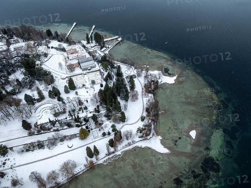 The wintry and snowy Mainau island in Lake Constance with the pier and the baroque Mainau Castle, built between 1739 and 1746, aerial view, district of Constance, Baden-Württemberg, Germany
