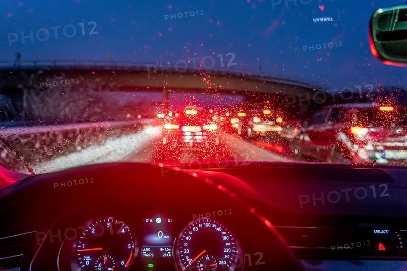 Driving in winter, in snow, motorway, rear lights, brake lights, speedometer, cockpit