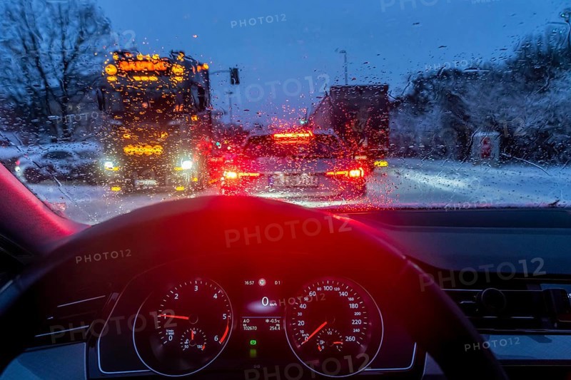 Driving in winter, in snow, rain, rear lights, brake lights, speedometer, cockpit