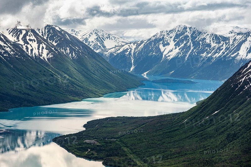 View of snowy mountains in spring and turquoise Kenai Lake with reflection, Slaughter Ridge Trail, Cooper Landing, Kenai Peninsula, Alaska, USA