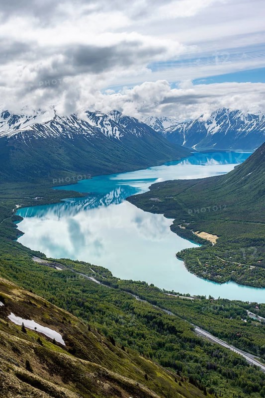 View of snowy mountains in spring and turquoise Kenai Lake with reflection, Slaughter Ridge Trail, Cooper Landing, Kenai Peninsula, Alaska, USA