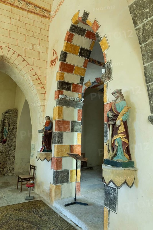 Painted arch in red, yellow and black. St Aignan's Church of Begues. Allier department. Auvergne Rhone Alpes. France. Europe