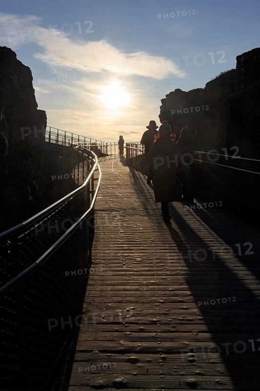 Walkers, tourists on hiking trail, Þingvellir National Park, impressive Almannagja Gorge, Allmännerschlucht, backlight, Golden Circle, Mid-Atlantic Ridge, Iceland